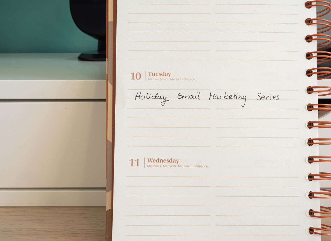 Services-02 Planner open on a desk with handwritten Holiday Email Marketing Series note.